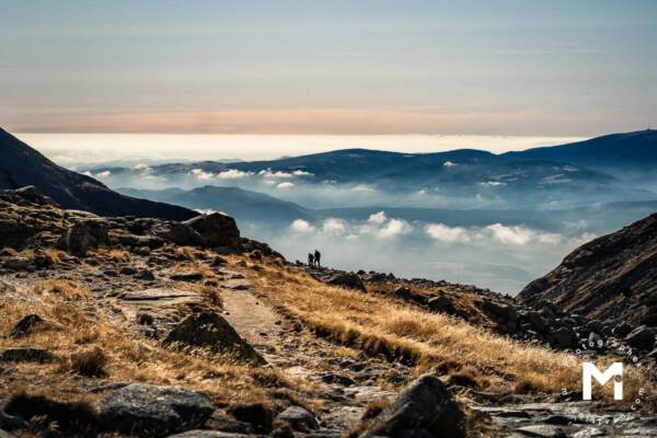 Hiking road in the mountains with clouds above