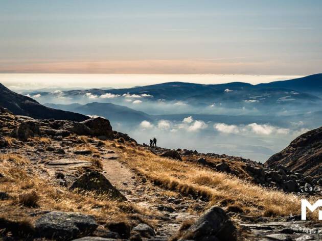 Hiking road in the mountains with clouds above
