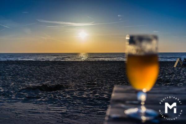 Sunset view at the ocean with the beer in the front