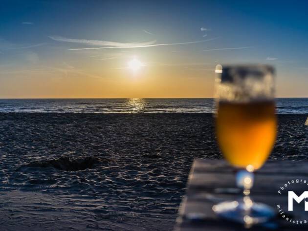 Sunset view at the ocean with the beer in the front