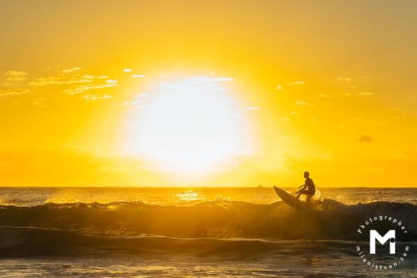 Surfer surfing at the sunrise light