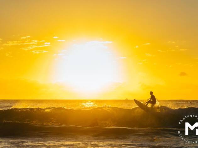 Surfer surfing at the sunrise light