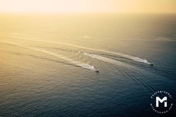 Boat drives against the current between 2 other boats