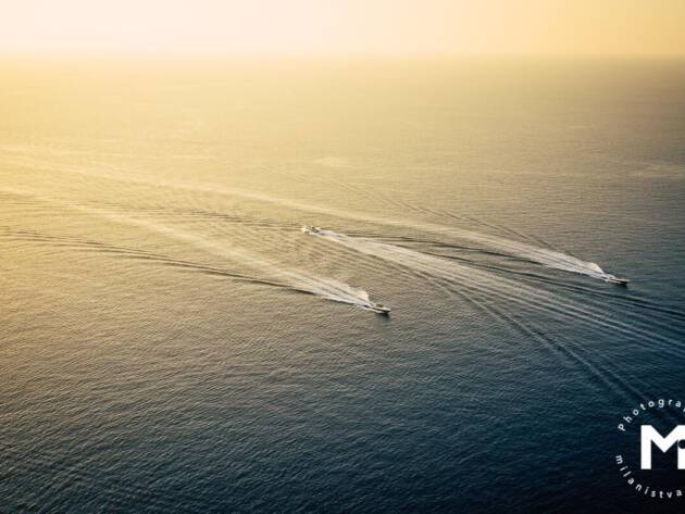 Boat drives against the current between 2 other boats